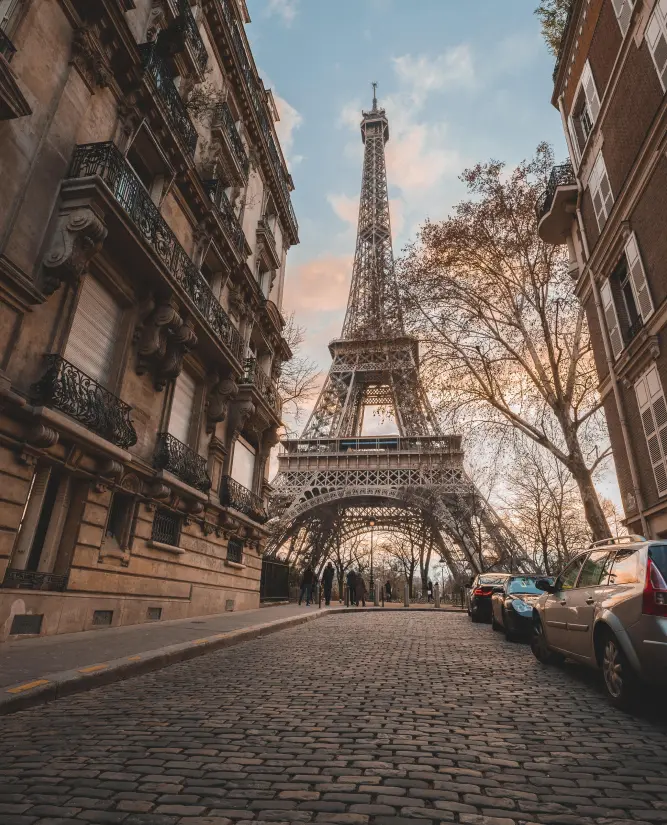 Photo d'une rue avec de beaux immeubles et la tour Eiffel au bout