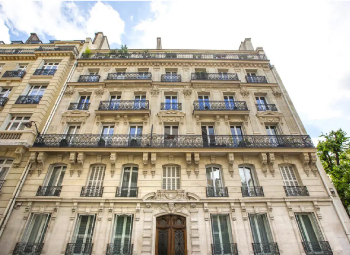 Photo d'une rue avec de beaux immeubles et la tour Eiffel au bout